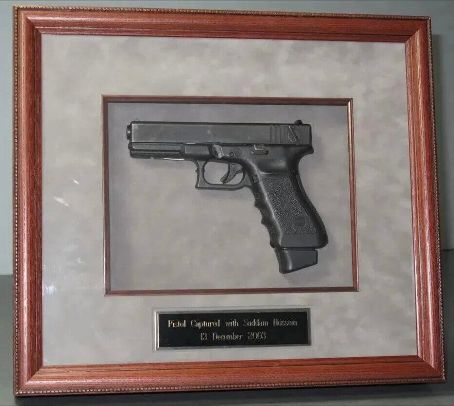 pistol in a frame.  hussein